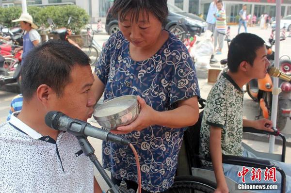 每天起床后便匆匆來到街頭“賣唱”，呂愛梅只能把面湯熬好在小強和小猛唱歌間隙喂他們吃。馬義恒 攝