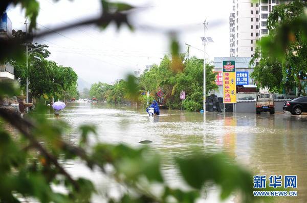 6月23日，在海南省三亞市，人們?cè)诜e水路段涉水前行。今年第8號(hào)臺(tái)風(fēng)“鯨魚”已于6月22日18時(shí)50分左右在海南省萬寧市沿海登陸，臺(tái)風(fēng)給三亞帶來了強(qiáng)風(fēng)降雨天氣，影響市民正常出行。新華社發(fā)（沙曉峰 攝）