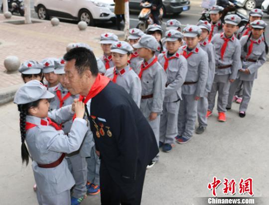 受谷殿明血雷鋒事跡的感染，雷鋒小標(biāo)兵為這位“活雷鋒”爺爺系上紅領(lǐng)巾。　郭園 攝