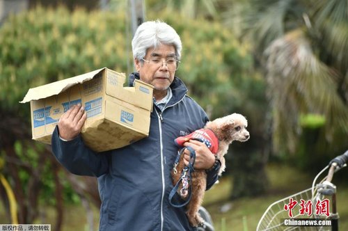 當地時間4月17日，一位老人抱著自己的愛犬領救災物資。