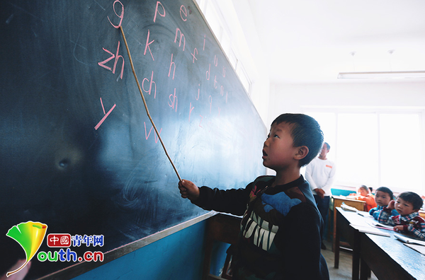 　　6歲的楊嚴(yán)國(guó)熟練地讀著黑板上的拼音字母。