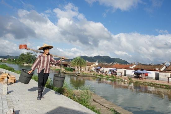 5月27日，埭美村一位村民挑桶經過村前小河