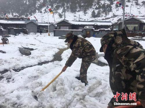 3月11日，西藏公安邊防總隊機動支隊應急二分隊官兵正在鏟除道路積雪。 張鈺 攝