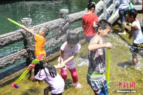 7月11日，幾名兒童在山東濟南“清泉石上流”池中戲水納涼。山東近日持續(xù)高溫，多地發(fā)布橙色高溫預(yù)警，局部地區(qū)氣溫達(dá)到39℃。<a target='_blank' href='http://www.chinanews.com/'>中新社</a>記者 張勇 攝