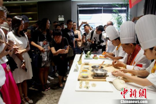 圖為烹飪大師現場廚藝表演，令華裔青年贊不絕口。　崔佳明 攝