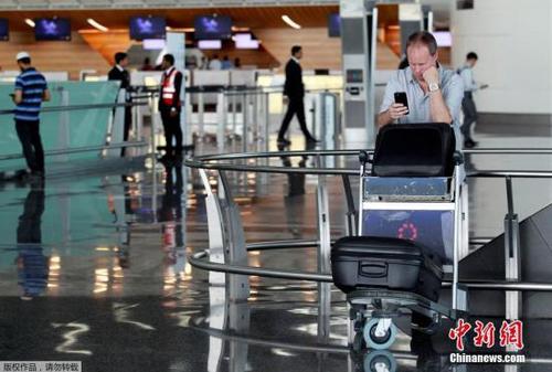 此前，阿聯酋航空、埃及航空等相繼暫停往返卡塔爾首都多哈的航班，沙特等國甚至禁止卡塔爾航空班機越過領空，令中東航空樞紐多哈的哈馬德國際機場陷入混亂。圖為一名游客在哈馬德國際機場看手機。