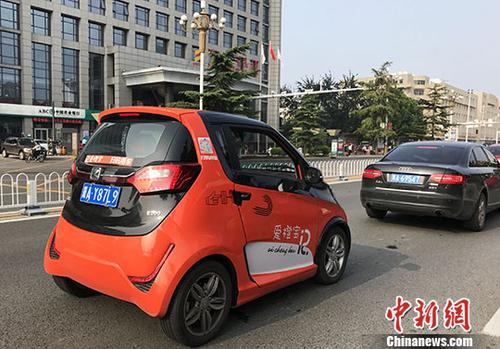 一輛橙色共享汽車正在行駛。 <a target='_blank' href='http://www.chinanews.com/'>中新社</a>記者 翟羽佳 攝