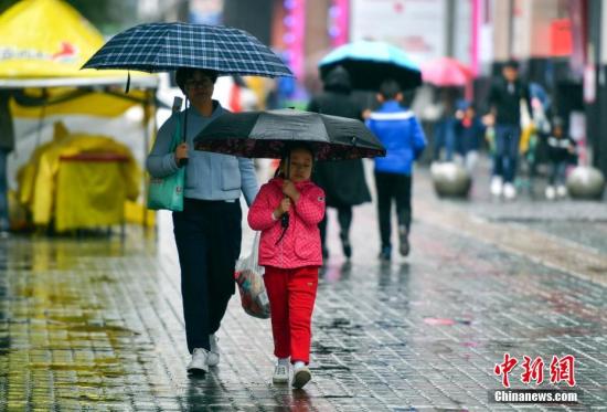 資料圖：9月24日，新疆烏魯木齊市降下秋雨，外出民眾打著雨傘快步前行。 <a target='_blank' href='http://www.chinanews.com/'>中新社</a>記者 劉新 攝