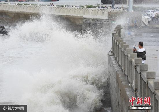 10月2日，游客在連云港市連云區海岸邊觀賞巨浪。當日，受冷空氣影響，江蘇連云港沿海出現大風，海濱掀起陣陣巨浪。據中央氣象臺預報，10月1日夜間至4日，冷空氣將自北向南影響我國中東部大部地區，長江中下游及其以北地區有4-5級風，陣風6-7級，日平均氣溫或最低氣溫將下降4-6℃，北方部分地區降溫幅度可達10℃以上。耿玉和 攝 圖片來源：視覺中國