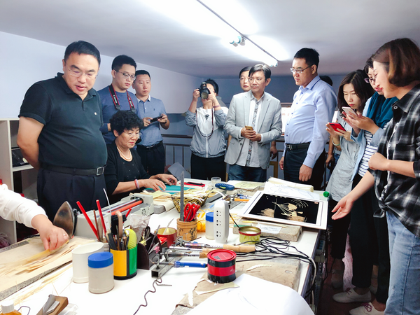 圖為：楊麗麗向領導們介紹麥秸畫制作過程