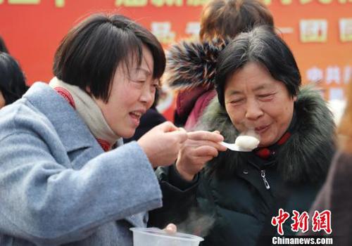 圖為民眾品嘗剛出鍋的湯圓。　胡小麗 攝