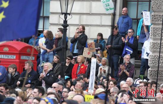 3月23日，在歐盟同意英國延遲脫歐、英國脫歐前景仍面臨“災難的不確定性”困境之際，倫敦市中心舉行了大規模呼吁舉行“第二次脫歐公投”的示威游行。名為“交給人民”的組織者聲稱，參加示威游行的英國民眾來自全國各地，超過一百萬人。圖為示威游行隊伍聚集在市中心議會廣場，密集的人群里三層外三層，水泄不通。<a target='_blank' href='http://www.chinanews.com/'>中新社</a>記者 張平 攝