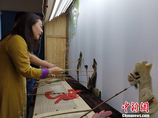 李娟藏在幕布后，繪聲繪色地為觀眾表演《西游記之孫悟空大戰(zhàn)蝎子精》。　趙曉 攝