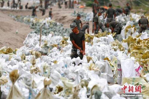 資料圖：7月25日，江西省九江市柴桑區江洲鎮北堤，中國人民解放軍第71集團軍某部官兵正在為防洪備料。